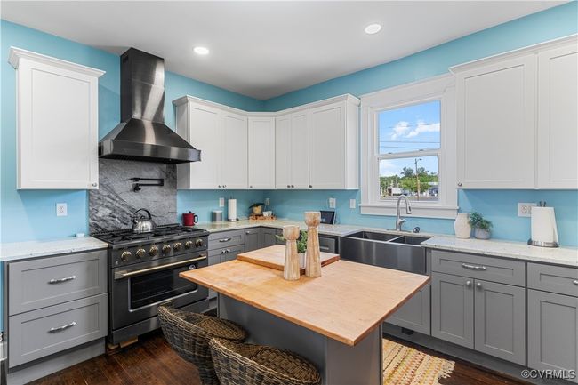 Kitchen with wall chimney range hood, gray cabinets, a sink, decorative backsplash, and stainless steel range | Image 13