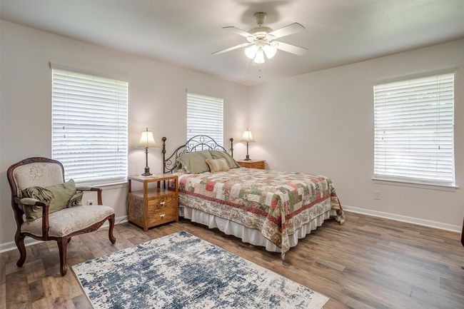 Bedroom with multiple windows, wood finished floors, and ceiling fan | Image 22
