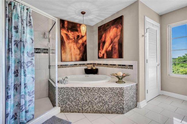 Bathroom with a shower stall, a garden tub, tile patterned flooring, and a closet | Image 24