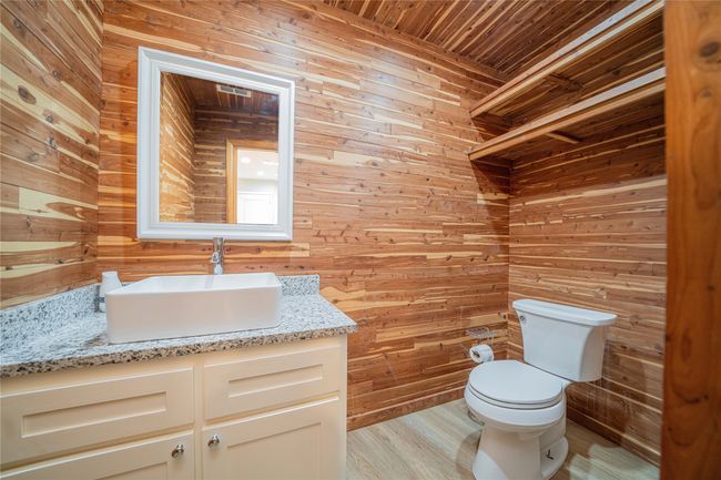 Half bath with wooden walls, vanity, wood ceiling, and wood finished floors | Image 22