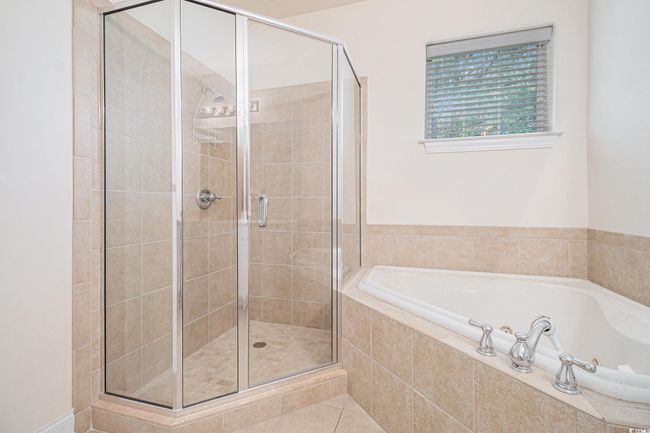 Bathroom with a bath, a shower stall, and tile patterned floors | Image 18