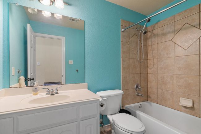Bathroom featuring vanity, a textured wall, and tub / shower combination | Image 29