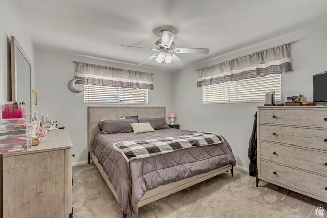 Bedroom with ceiling fan, baseboards, and light colored carpet | Image 9