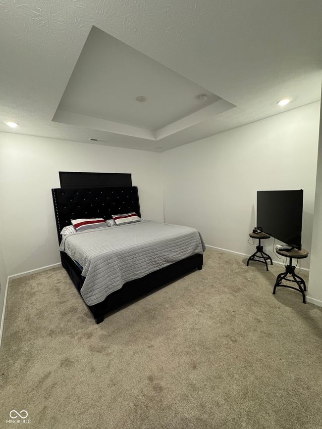 carpeted bedroom featuring recessed lighting, baseboards, and a raised ceiling | Image 14