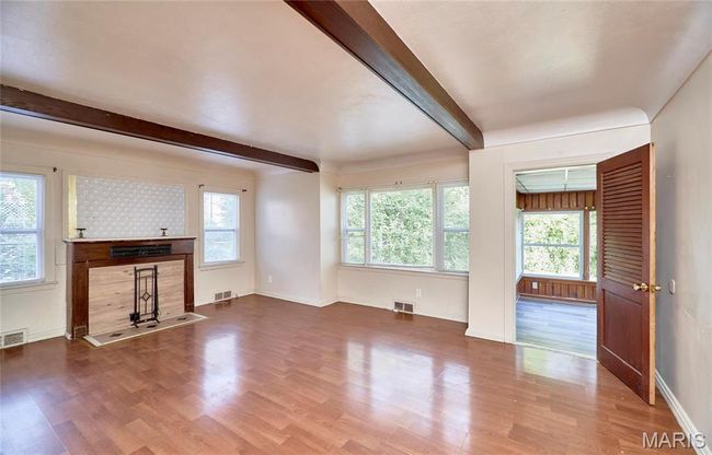 Unfurnished living room featuring beamed ceiling and hardwood / wood-style flooring | Image 7