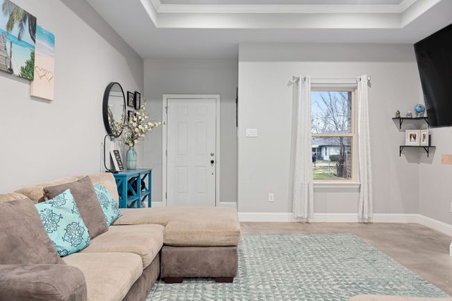 Living room with crown molding, a tray ceiling, and light hardwood / wood-style floors | Image 4
