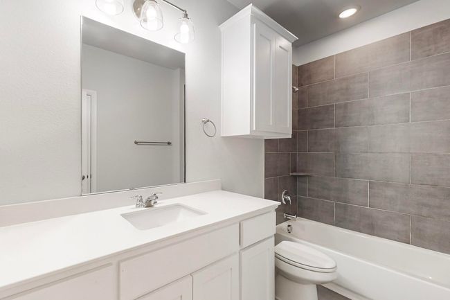 Full bathroom featuring vanity, tiled shower / bath combo, and toilet | Image 20