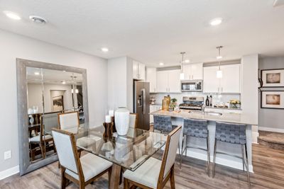 (Photo of decorated model, actual home's finishes may vary slightly) Enjoy plenty of seating at the kitchen island and dining area adjacent to the kitchen. Perfect for entertaining or having a family meal together. | Image 1