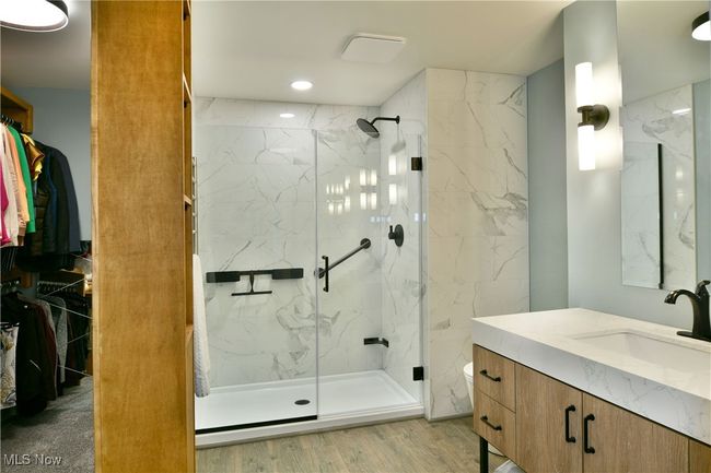 Full bath with toilet, wood finished floors, a marble finish shower, and vanity | Image 30