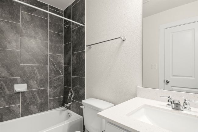 Full bathroom with toilet, a textured wall, tub / shower combination, and vanity | Image 25