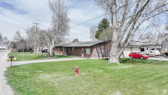Ranch-style home with a front yard, brick siding, driveway, and a chimney | Image 48