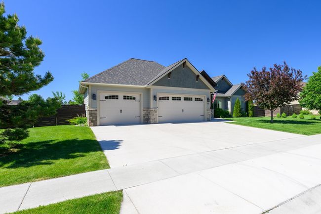 Craftsman house with a garage, driveway, stone siding, and a shingled roof | Image 5