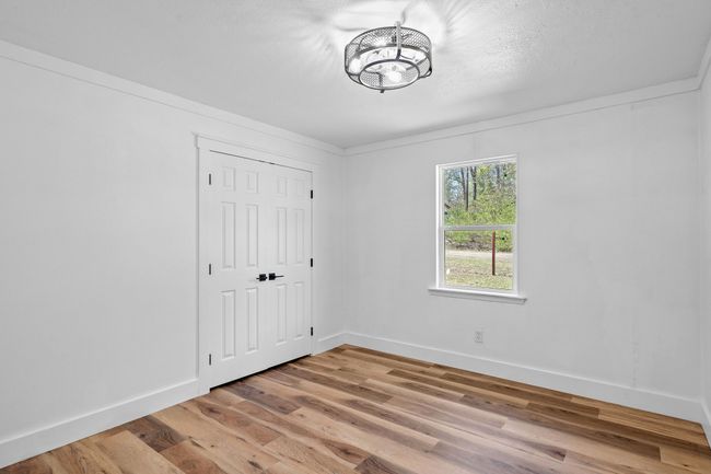 Unfurnished bedroom featuring a closet, light wood-style flooring, a chandelier, and baseboards | Image 32