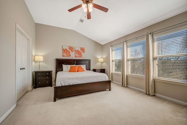 Primary bedroom with a wall of windows and a vaulted ceiling. | Image 31