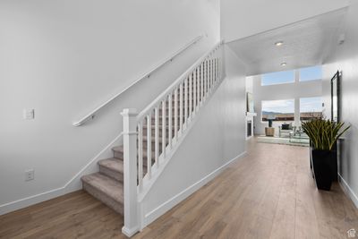 Staircase featuring wood-type flooring and a high ceiling | Image 2