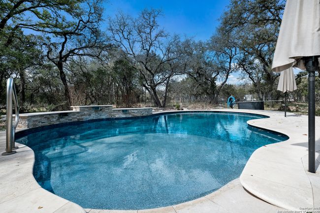 Fenced in, heated pool, with water features | Image 27