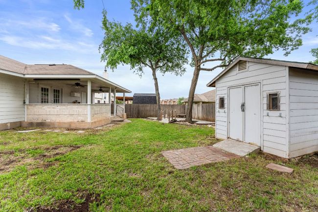 View of yard with a fenced backyard, ceiling fan, an outbuilding, and a storage shed | Image 34