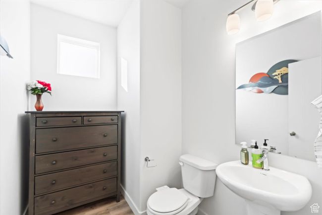 Bathroom with wood finished floors, toilet, baseboards, and a sink | Image 16