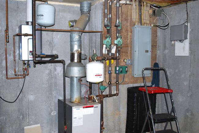 Utilities featuring electric panel and gas burner and tankless hot water heater | Image 39