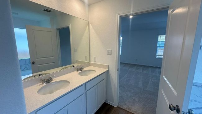 Full bathroom with a textured wall, double vanity, and dark wood-style flooring | Image 29