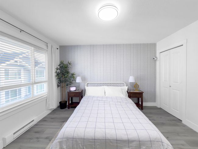 Bedroom featuring wallpapered walls, an accent wall, baseboard heating, wood finished floors, and a closet | Image 15