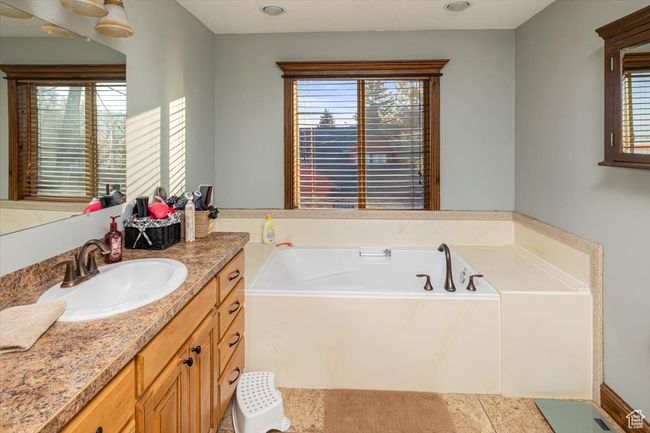 Bathroom with vanity and a tub to relax in | Image 20