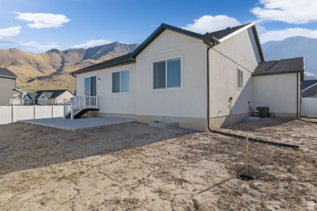 Rear view of house featuring a patio, central AC, fence, and a mountain view | Image 7