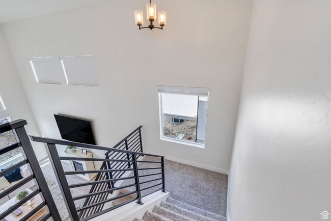 Stairway featuring a chandelier, baseboards, and carpet | Image 13
