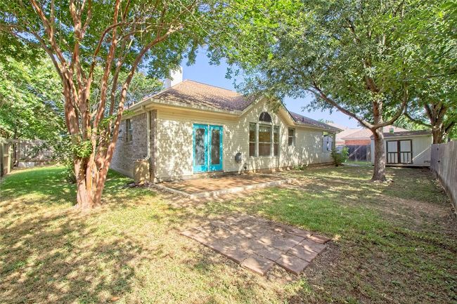 Rear view of property featuring a fenced backyard, a storage shed, and a chimney | Image 27