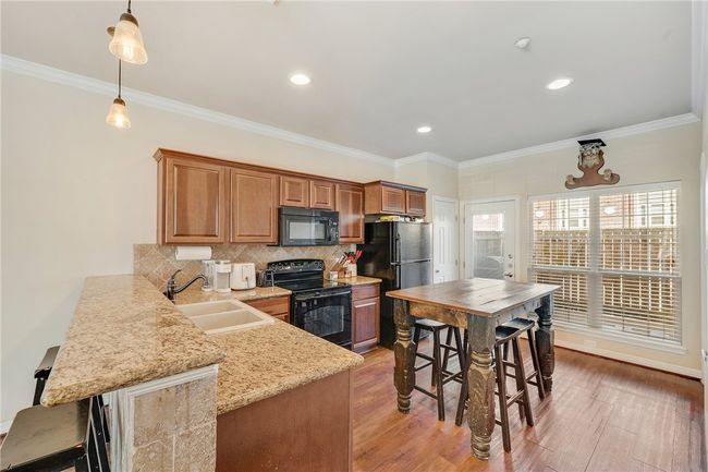 Large kitchen offers a eating bar and all appliances including refrigerator. | Image 4