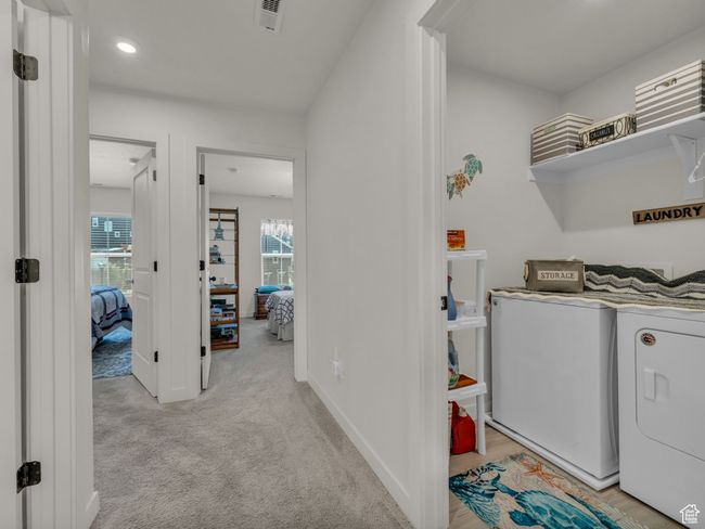 Laundry room featuring independent washer and dryer, light carpet, baseboards, and recessed lighting | Image 14