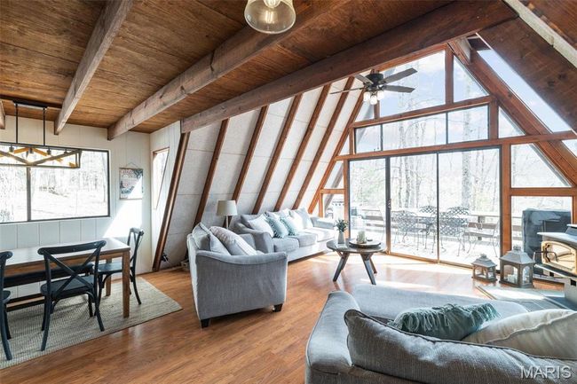 Living area featuring a wealth of natural light, expansive windows, wood ceiling, and wood finished floors | Image 4