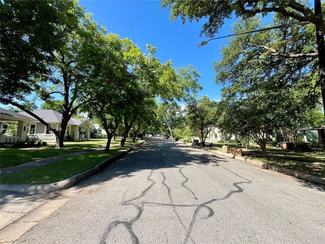 View of asphalt street with curbs, sidewalks, and street lights | Image 36