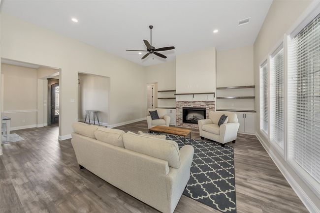 Living area featuring dark wood finished floors, recessed lighting, baseboards, a brick fireplace, and ceiling fan | Image 19