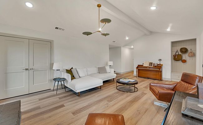 Living room with a modern chandelier, light wood finished floors, and recessed lighting | Image 9