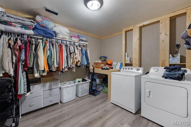 Laundry room with washer and dryer and light wood finished floors | Image 13
