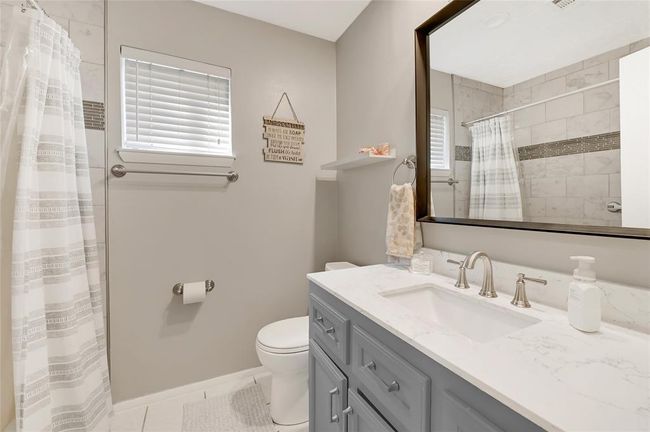 Elegant full bathroom featuring modern fixtures, a sleek vanity, and a spacious shower for ultimate relaxation. | Image 15