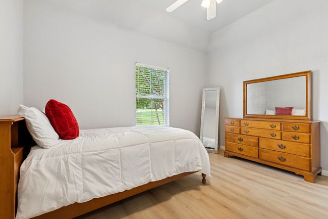 Bedroom featuring light wood finished floors and ceiling fan | Image 26