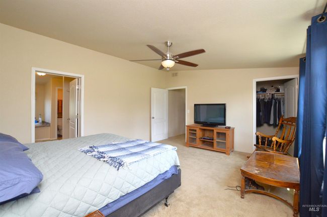 Bedroom with light colored carpet, a closet, a walk in closet, and ceiling fan | Image 15