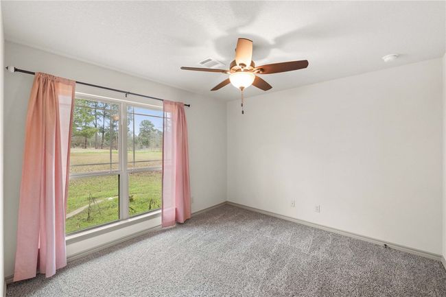 Carpeted empty room with plenty of natural light, baseboards, and ceiling fan | Image 17
