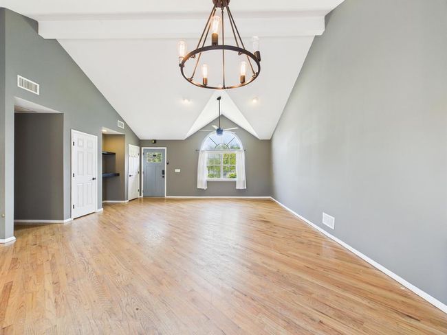 Unfurnished living room featuring a chandelier and light wood-style flooring | Image 15