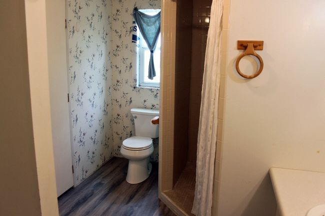 Bathroom with wood finished floors, a shower stall, and toilet | Image 40