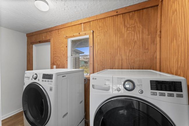 Laundry room with a small window providing natural light. | Image 30