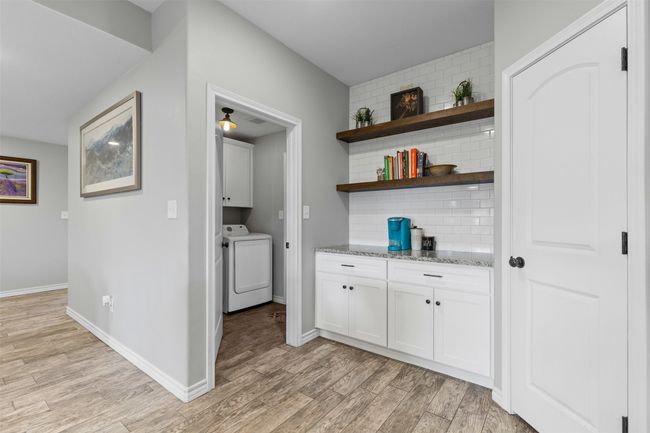 Laundry area with cabinet space, light wood finished floors, baseboards, and washer and dryer | Image 15