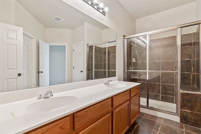 Bathroom with a stall shower, visible vents, and a sink | Image 9