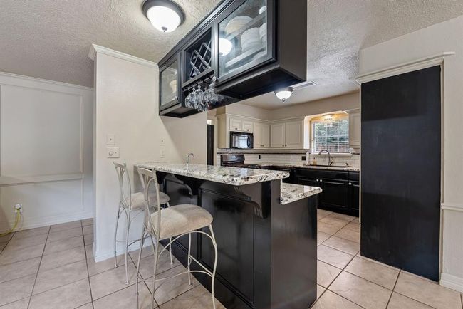 High breakfast bar is perfect for grabbing a quick snack or chatting with the cook. | Image 12