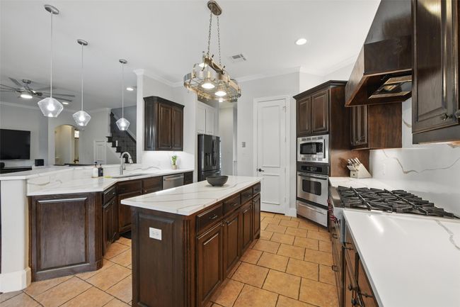 Granite was extended to the backsplash for a seamless classy look and cabinets were professionally retained. | Image 15