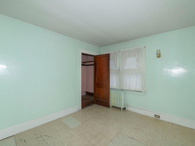 Unfurnished bedroom with radiator, light floors, and a closet | Image 28