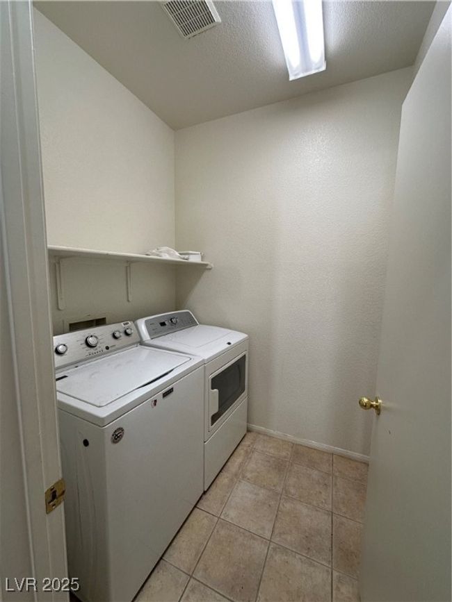Washroom with washer and clothes dryer, light tile patterned floors, and baseboards | Image 20