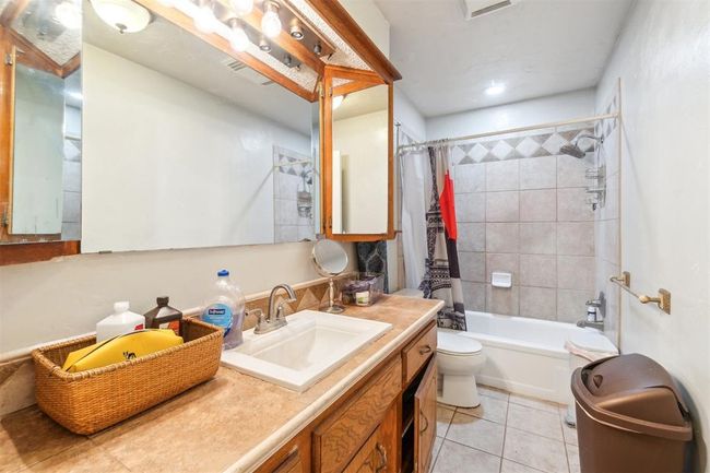 Bathroom featuring tile patterned floors, vanity, and shower / tub combo with curtain | Image 28